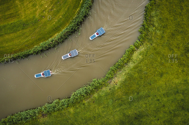 Aerial view of solar panel boats navigating through the farmlands of Schettens, Friesland, The Netherlands.