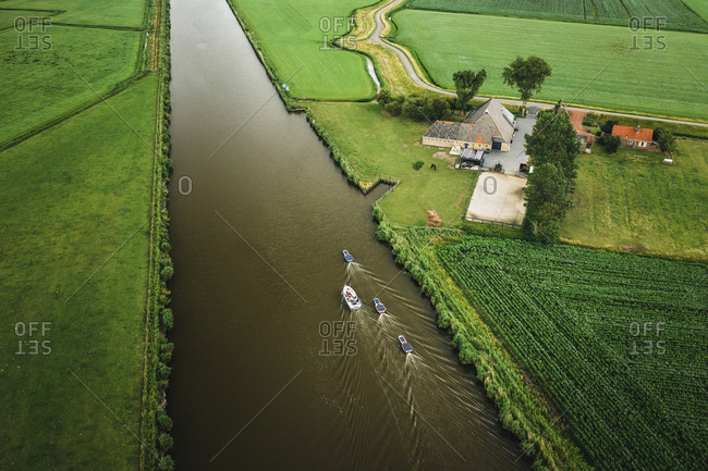 Aerial view of solar panel boats navigating through the farmlands of Harlingen, Friesland, The Netherlands.