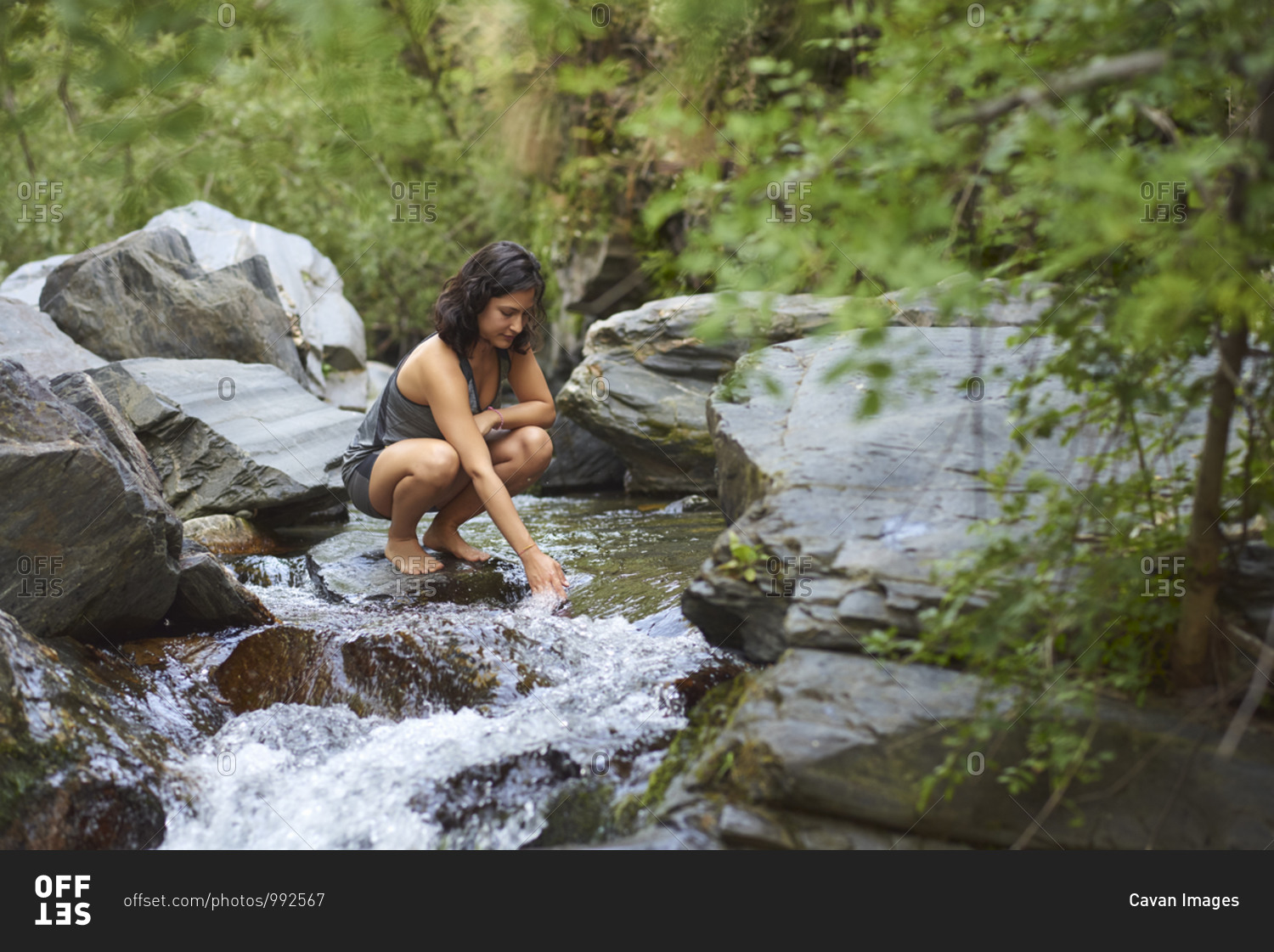 Young woman in a river. Refreshes on a hot summer afternoon.