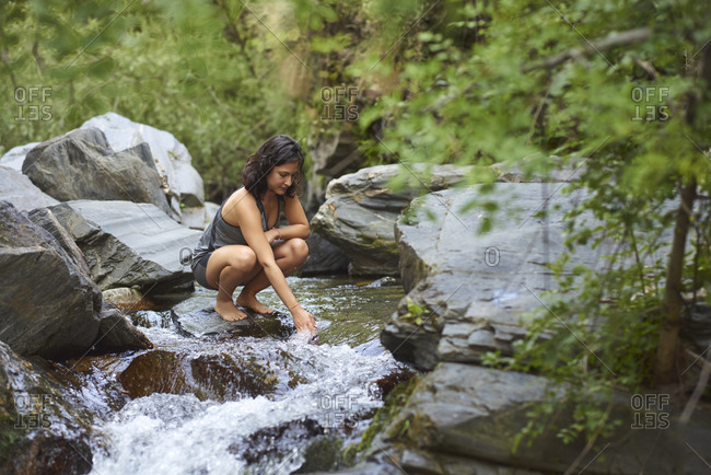 Young woman in a river. Refreshes on a hot summer afternoon.