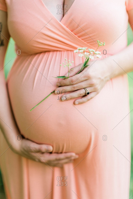 Close up of an expecting mother cradling her pregnancy bump