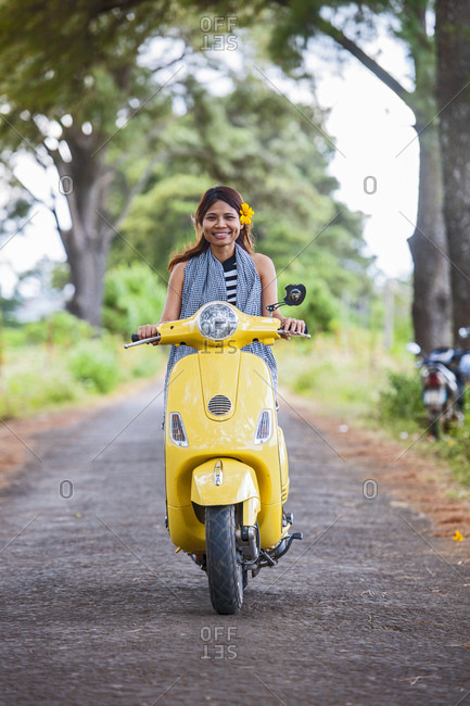 Vietnamese woman with yellow scooter in rural area in Vietnam