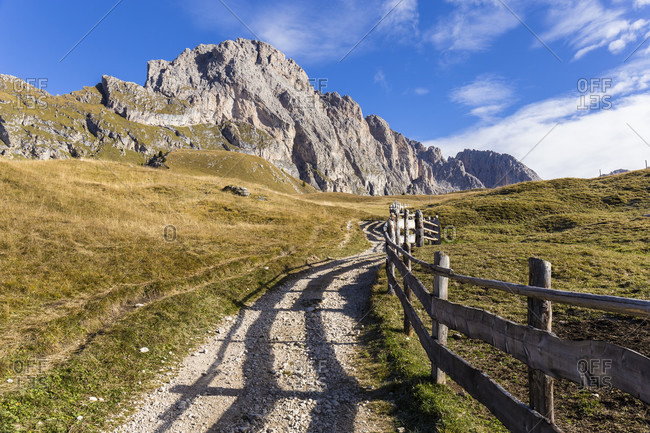 Trail along a fence in front of the Geislerspitzen or Odle Range, Puez-Geisler Nature Park, UNESCO World Heritage Site, Dolomites, Alps, Alto Adige, Tentino, South Tyrol, Italy