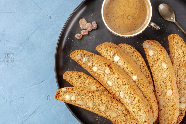 Cantucci, traditional Italian almond biscuits, with a cup of coffee, overhead shot with a place for text