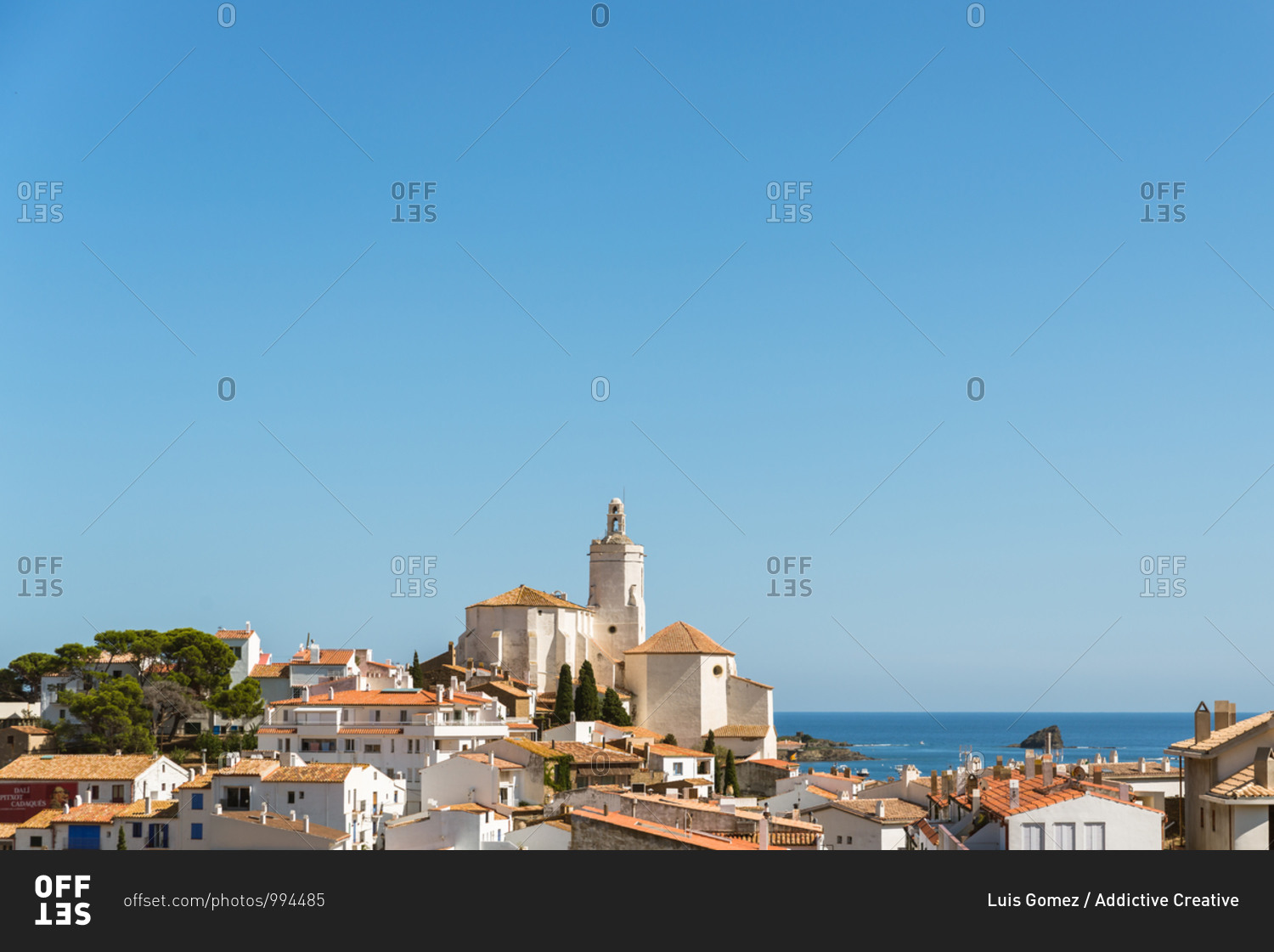 Picturesque view of old small Cadaques town located on bay of Mediterranean sea in sunny summer day with calm blue water