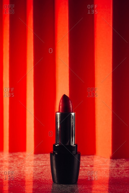 Red lipstick in elegant shiny tubes placed on red background
