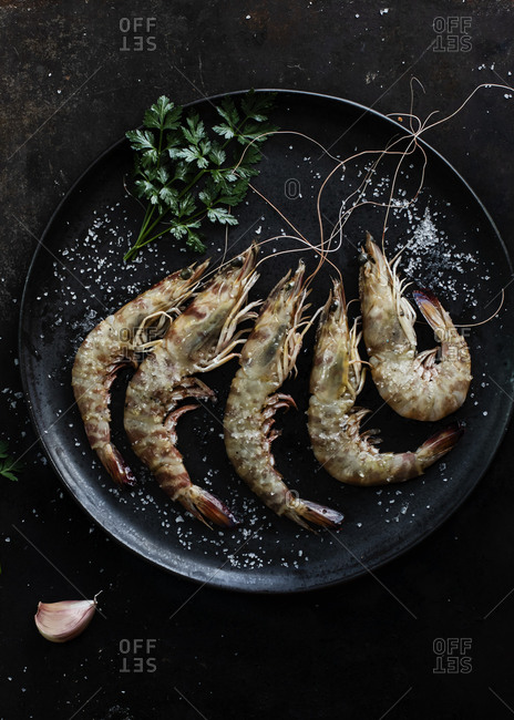 Prawns served in plate on table on dark background