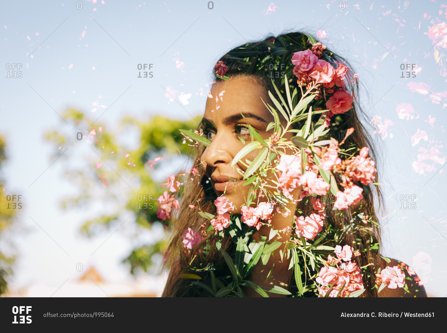 Double exposure of thoughtful young woman and flowers against clear sky