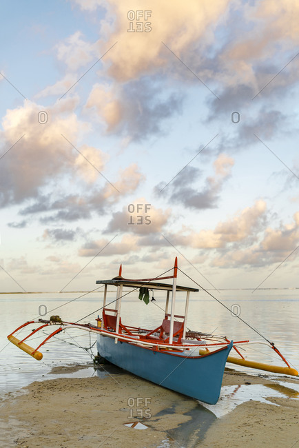Philippines- Siargao- General Luna- Fishing boat on beach at sunset