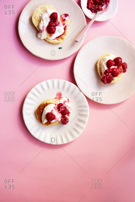 Scones with cream and raspberry coulis on a pink background