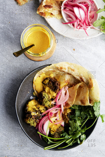 Falafels in a naan wrap with pickled red onions and a curry dipping sauce