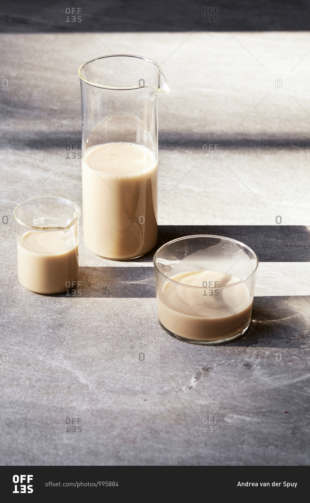 Three glass containers with long shadows filled with milk alternatives