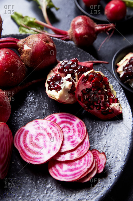 Close up of sliced beetroots and pomegranate on a place