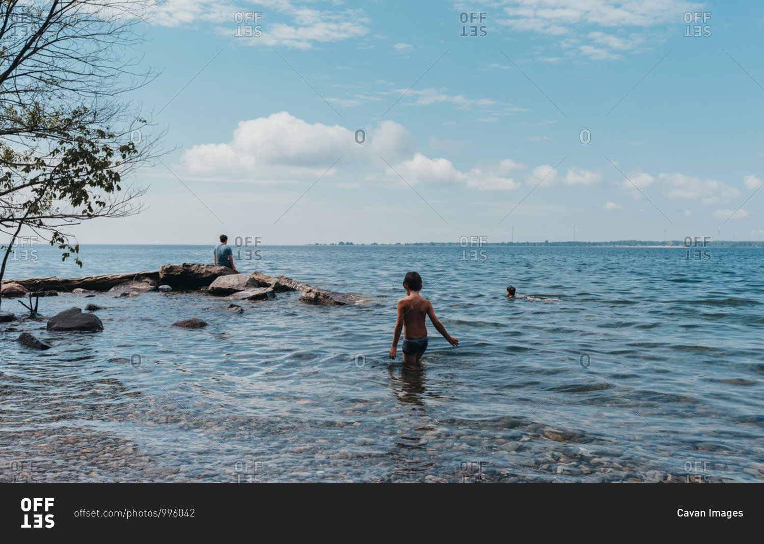 Children wading and swimming in lake ontario on a hot summer day.