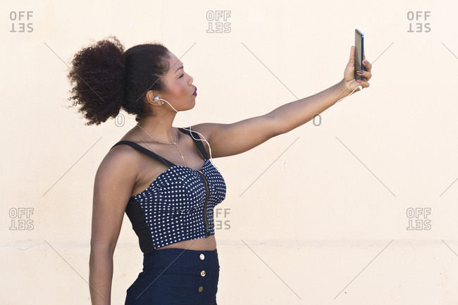 Black woman makes a selfie with her cell phone