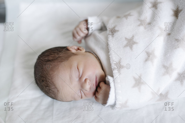 Newborn baby boy sleeping on a blanket stock photo - OFFSET