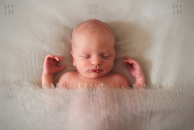 View from above of baby newborn sleeping covered with a blanket