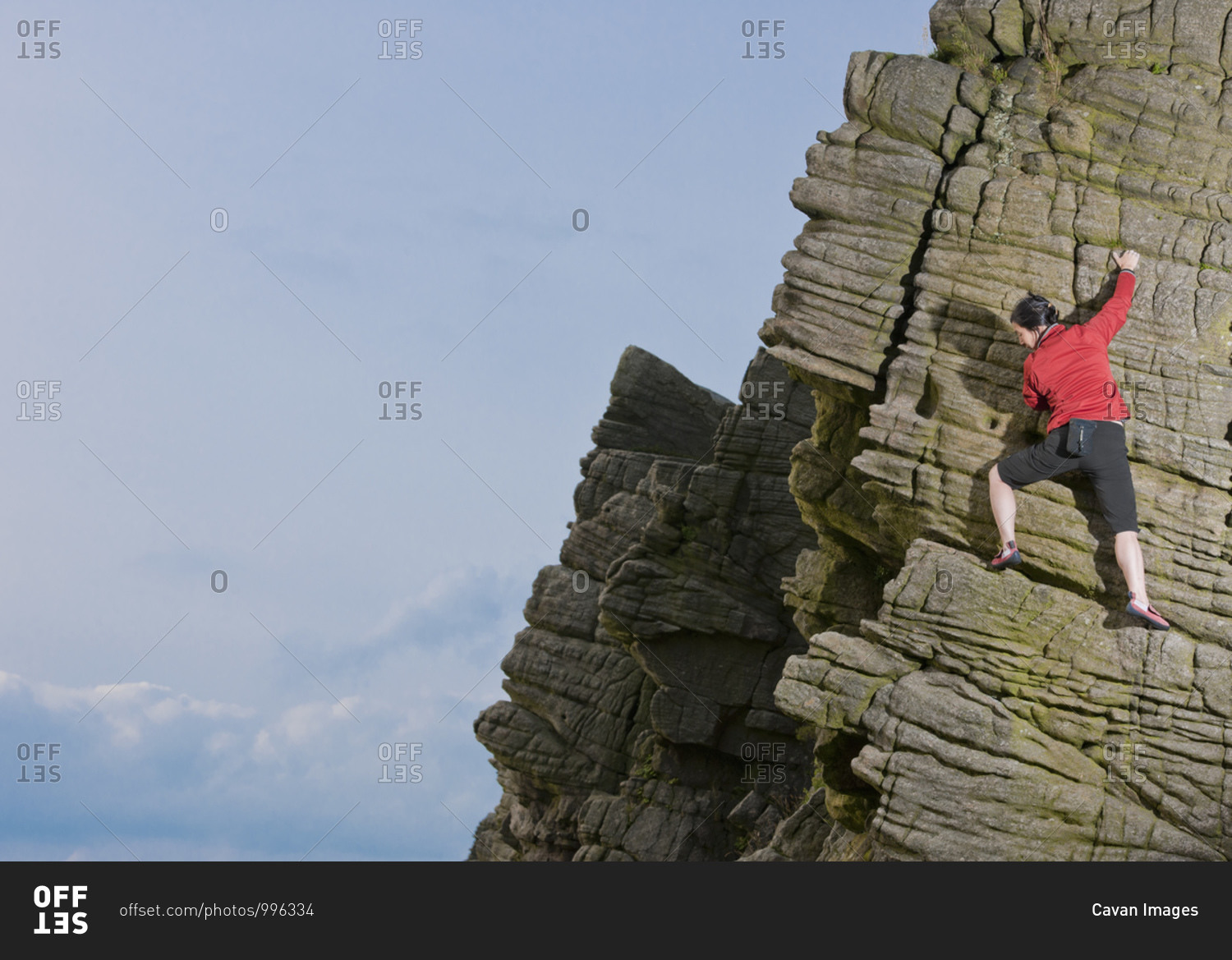 Woman climbing at wind gather rocks in the british peak district