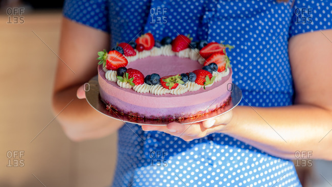 Woman holds in a hands a gluten-free cake