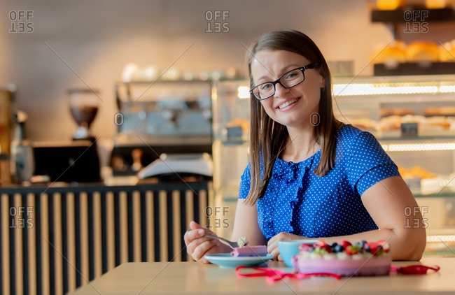 Woman eating a gluten-free cake in cafe