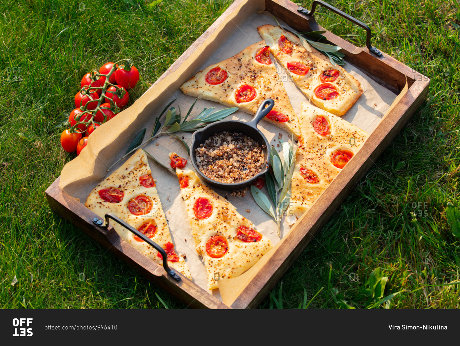 Traditional Italian focaccia bread and pan with salt on a tray outdoors
