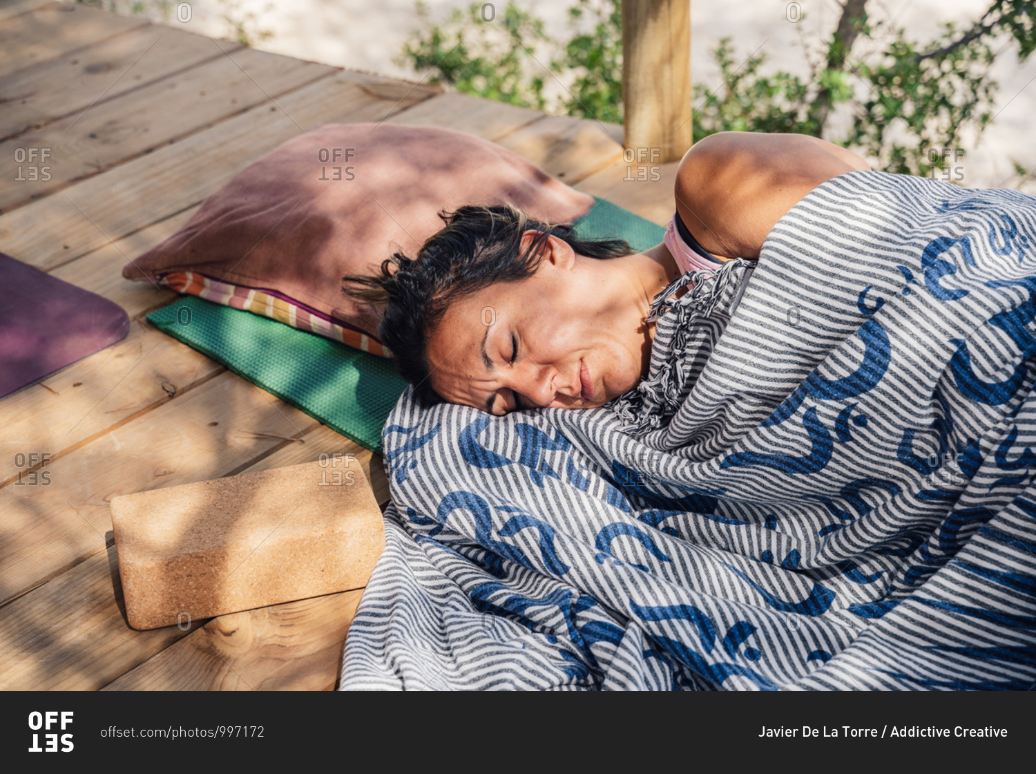 From above of middle aged woman sleeping on mat in garden after outdoor yoga lesson