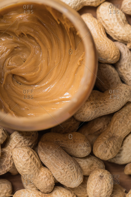 Vertical shot of the knife buttering the tasty peanut butter on the white  surface Stock Photo by wirestock