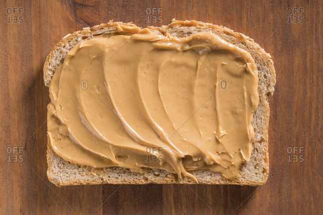 Vertical shot of the knife buttering the tasty peanut butter on the white  surface Stock Photo by wirestock