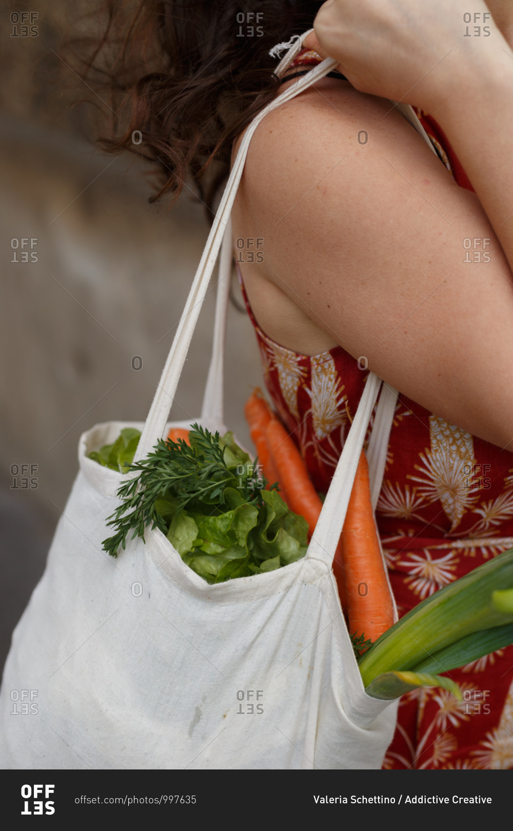 Side view cropped unrecognizable female standing with reusable shopping bag full of groceries during coronavirus epidemic