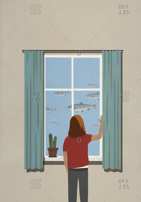 Woman looking at swimming fish from window