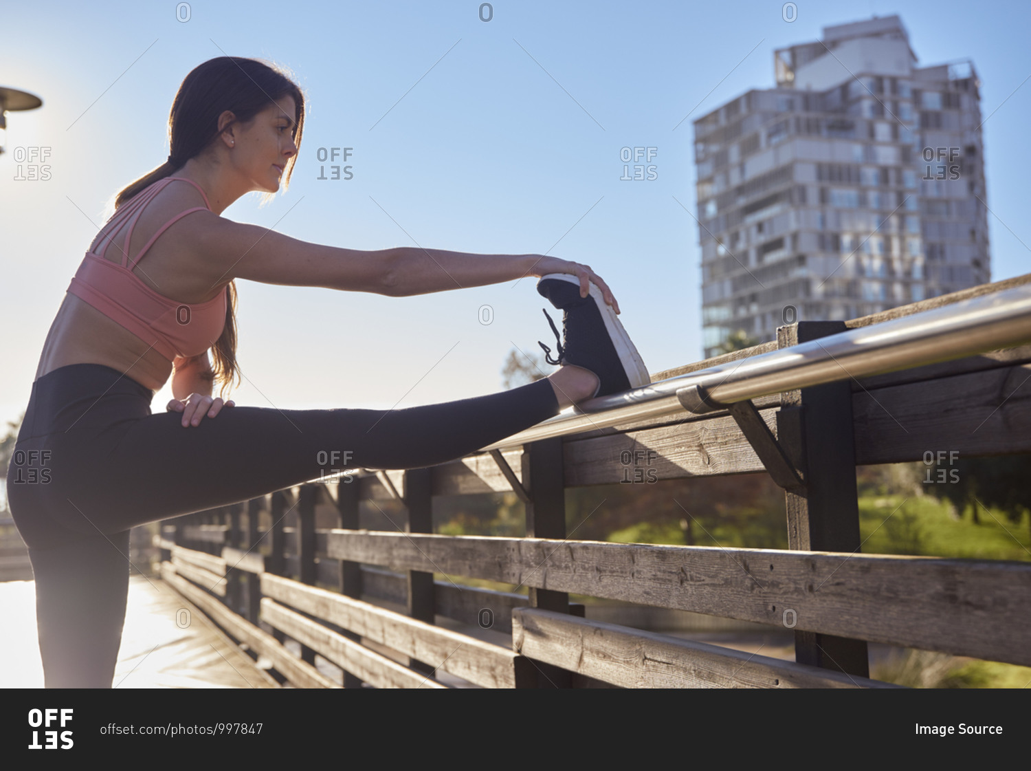 Woman stretching in city park, Barcelona, Catalonia, Spain