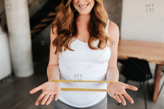 Pregnant woman doing strengthening exercise with bands