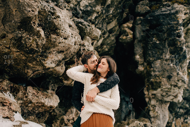 Couple hugging beside rock face, Tobermory, Canada