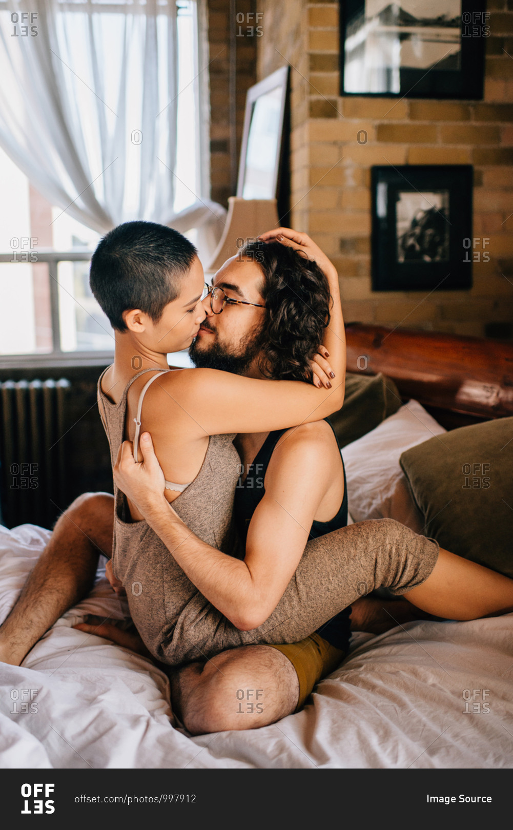 Couple hugging sitting on bed - Stock Image - Everypixel