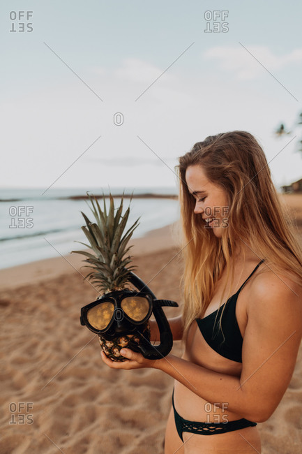 Scuba diver putting goggles on pineapple, Princeville, Hawaii, US