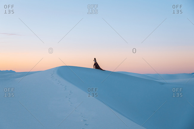 Woman on white sand dunes, White Sands National Monument, New Mexico, US