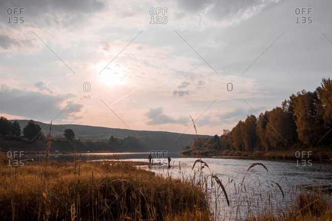 Anglers fishing at lake in autumn, Russia