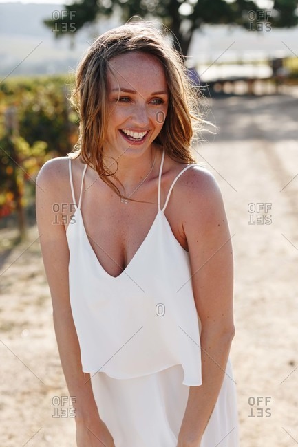 Woman laughing in sunshine in vineyard, Cape Town, South Africa