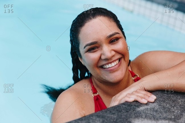 Mid adult woman with wet hair resting on outdoor swimming poolside, head and shoulder portrait, Cape Town, South Africa