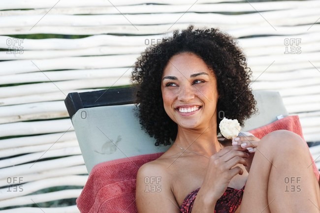 Woman enjoying ice cream on deckchair