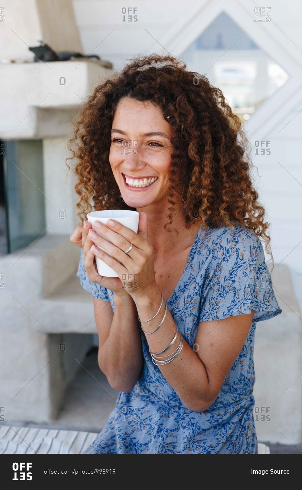 Woman enjoying hot drink clasped in hands at home