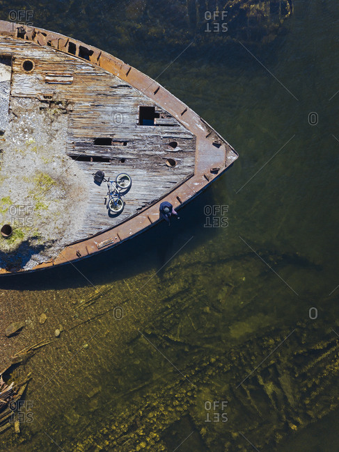 Russia- Murmansk region- Kolsky District- Teriberka- Man with bicycle at old ship deck- aerial view