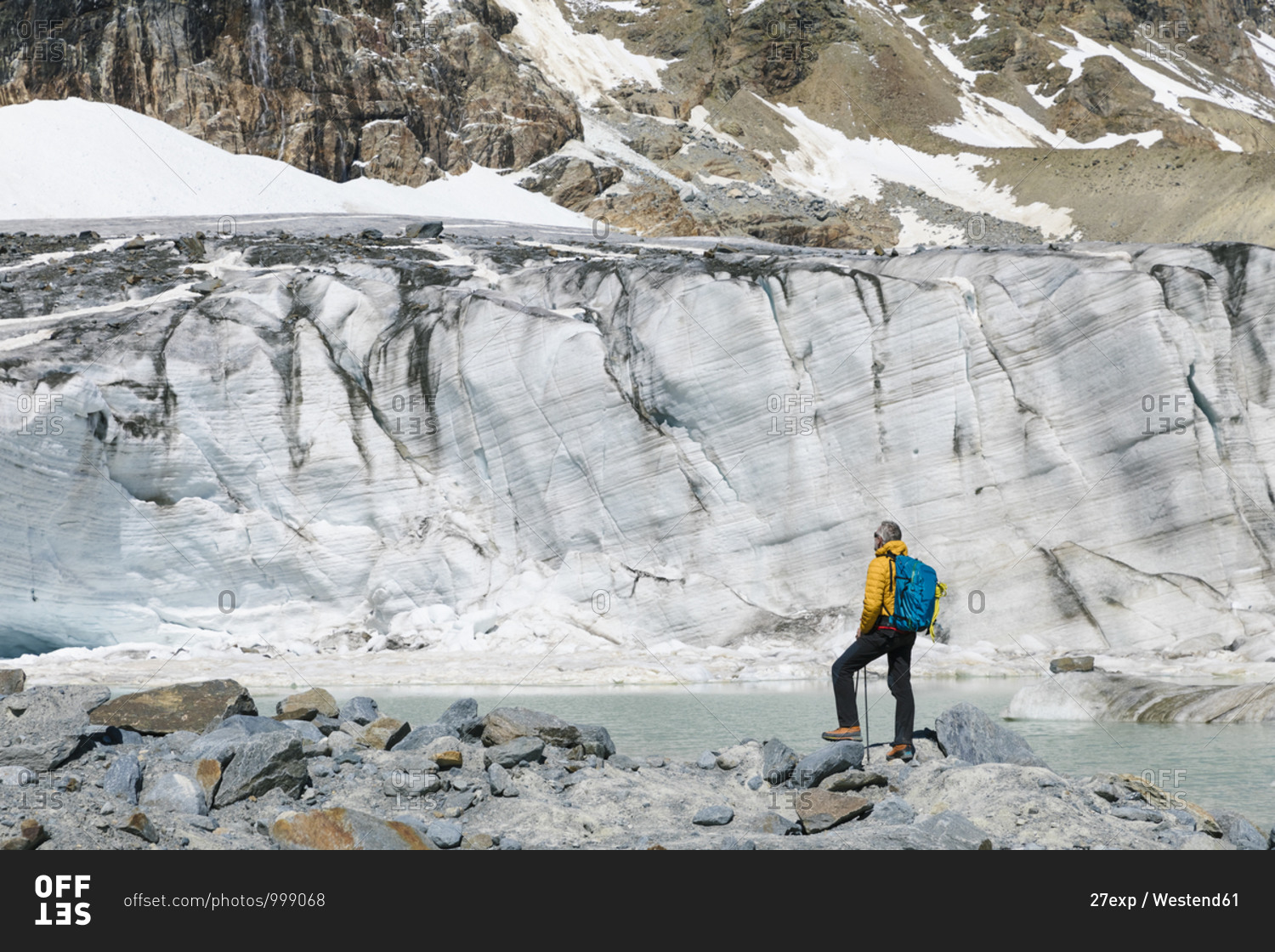 Mature male hiker looking at melting glacier