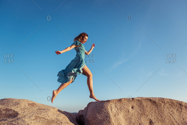 woman jumping off cliff