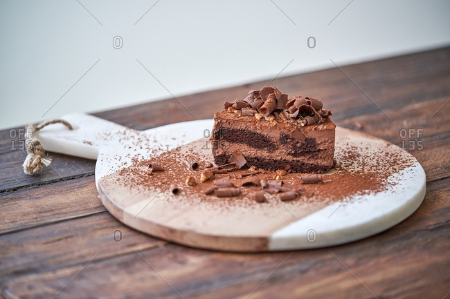 Delectable halved chocolate mousse cake served on wooden board on table