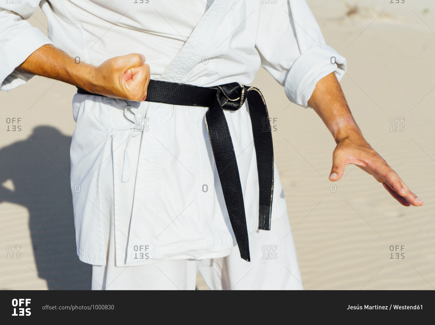 Close-up of mature man practicing karate while standing at beach