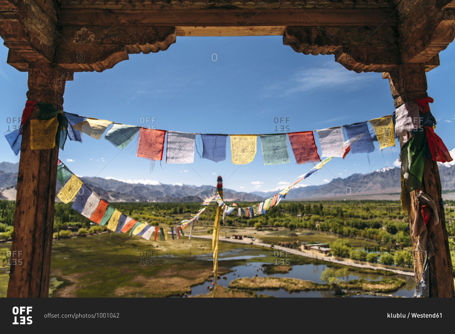 India- Ladakh- Colorful prayer flags hanging between two old columns