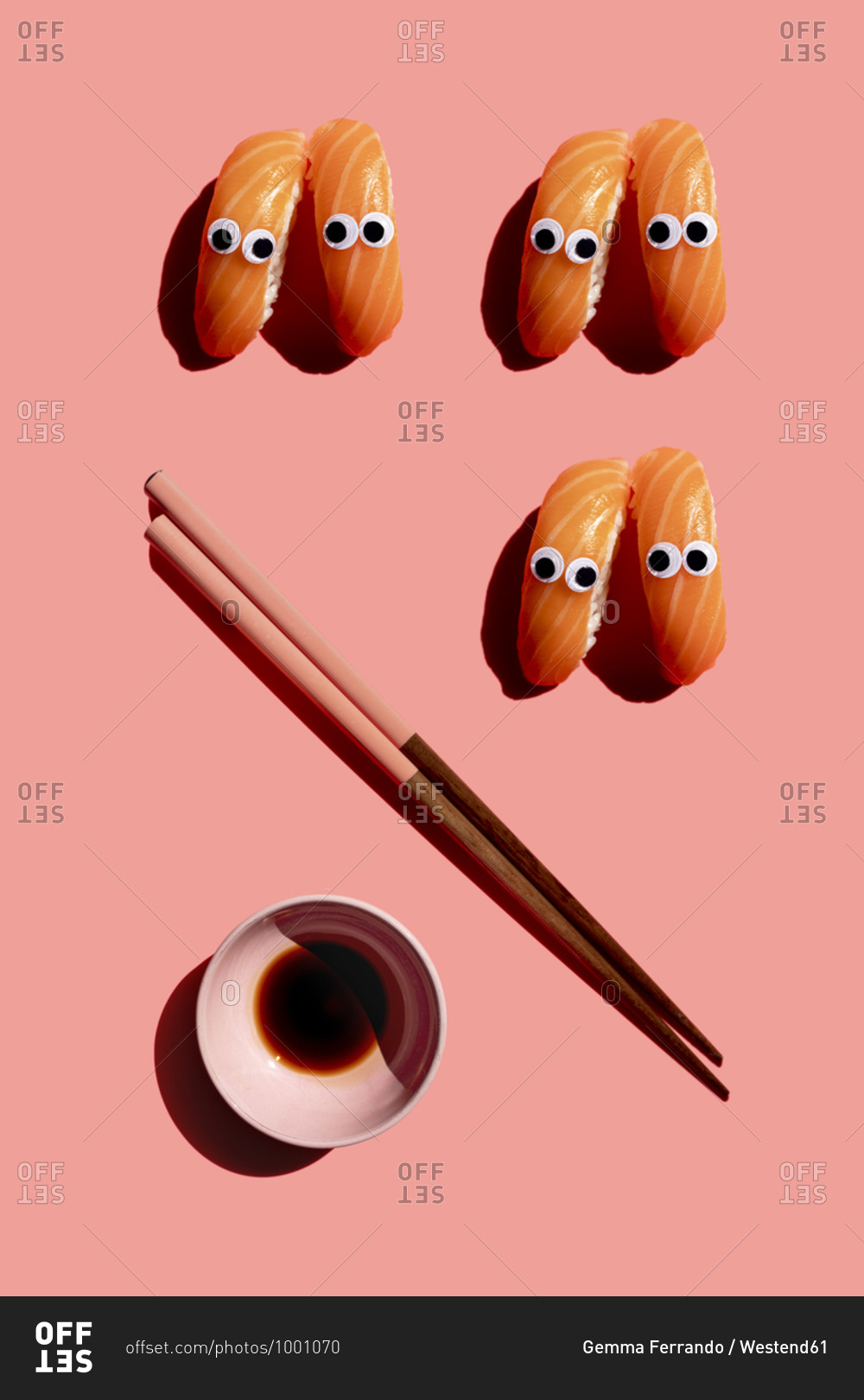 Studio shot of chopsticks- bowl of soy sauce and salmon nigirizushi pieces with googly eyes