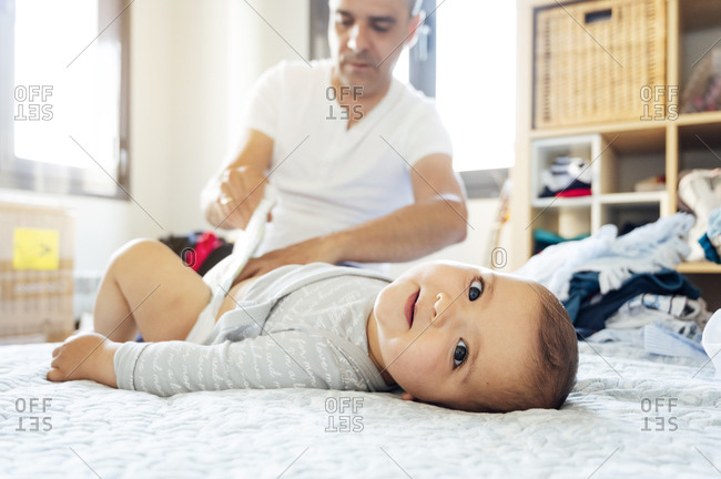 Father changing baby's diapers at home