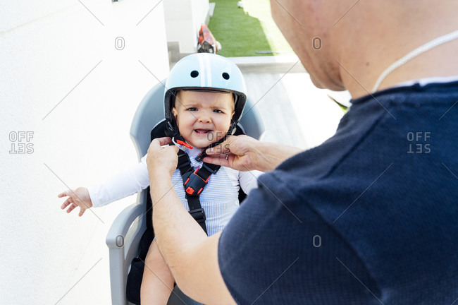Father with son sitting in safety seat of bicycle